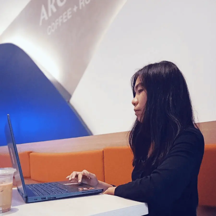 Cloney Mari Carandang working on a laptop at a coffee shop