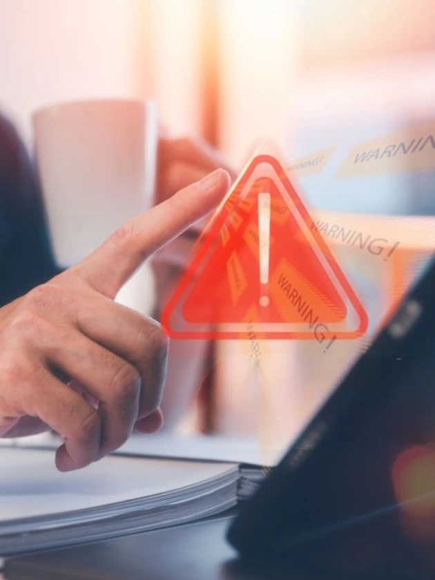 Finger pointing at a digital warning icon on screen